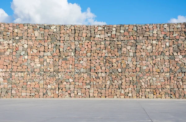 Decorative wall from rocks and metal wires.