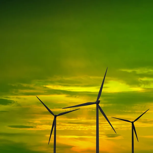 Drie windmolens tegen de achtergrond van de groen-gele-zonsondergang — Stockfoto