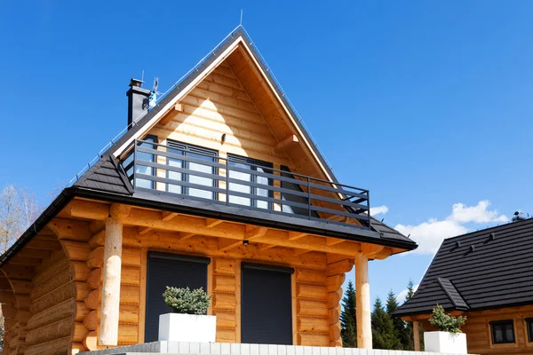 Bonita casa de madera con balcón, en una colina bajo un cielo azul — Foto de Stock