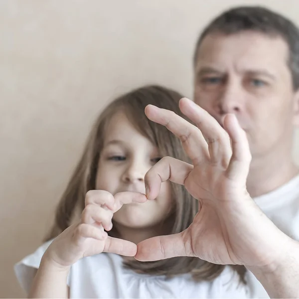 Boldog, szeretetteljes családi portré. Apja és az ő lánya gyermek lány játszik. Aranyos baba és a papa. Fogalma az apa nap. Családi nyaralás és az együttlét örömét. Alkotó kézzel szív, szeretet jelképe — Stock Fotó