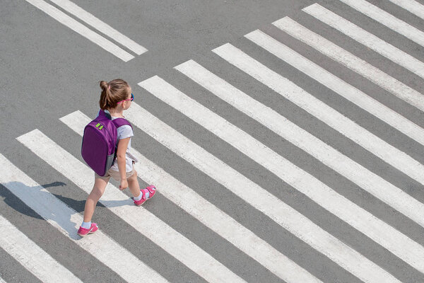 Schoolgirl crossing road on way to school