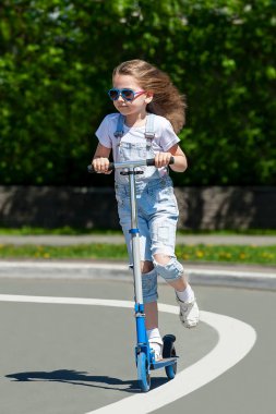 Mobilete binen çocuk. Renkli tekme tahtasında bir çocuk. Etkin açık hava