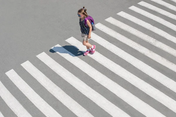 Colegiala cruzando la calle camino a la escuela. Tráfico de cebra — Foto de Stock