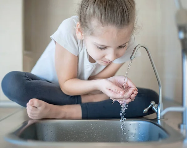 Caucásico niña bebiendo agua dulce en la cocina en casa — Foto de Stock