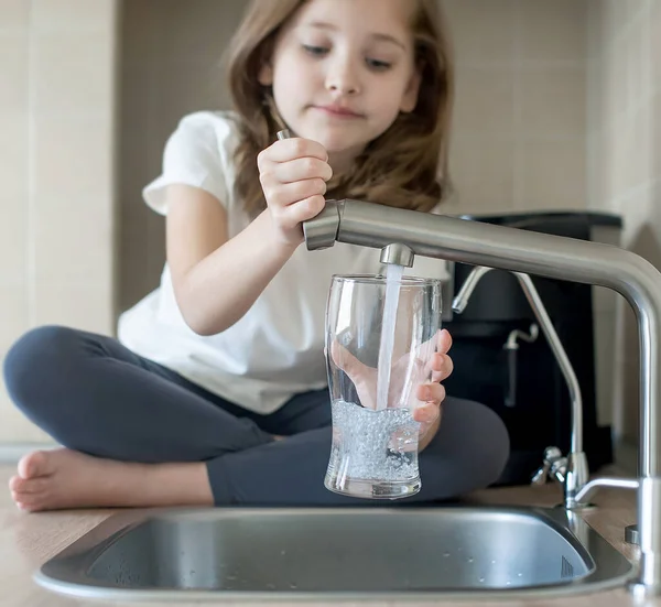 Menina Abre Uma Torneira Água Com Mão Segurando Copo Transparente — Fotografia de Stock