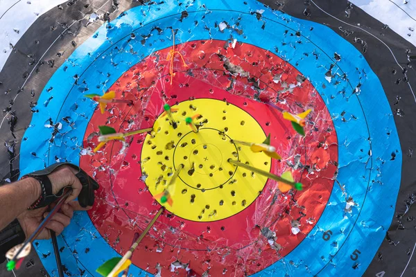 Okçuluk hedefi, içinde oklar var ve bir kişi içeri giriyor. 