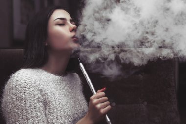 Bir kız nargile içiyor, sigara üflüyor, bir loa kızı nargile tüttürüyor, duman üflüyor, bir sürü duman çıkarıyor, bundan zevk alıyor, bir duman tekmesi, bundan zevk alıyor,