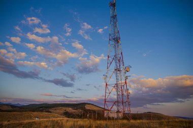 Yüksek voltaj kulesiyle sonbahar sahasında gün batımı