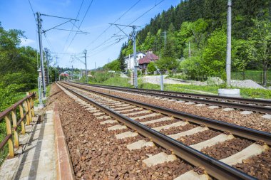 Yeşil bahar dağlarından geçen demiryolu.