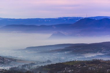 Gün batımında renkli gökyüzü ile karlı kış dağları