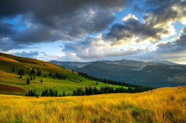 Akşam gökyüzü ve dağların güzel manzarası, çayır çimenli tepeler