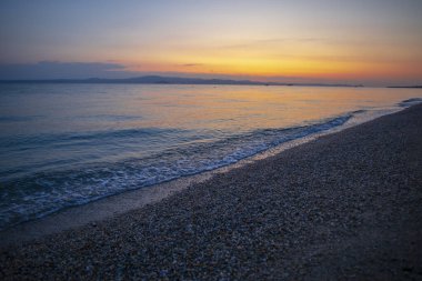 Deniz manzarası ve gökyüzünde gün batımı