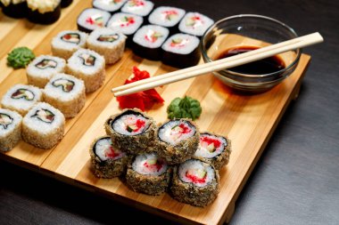 Lezzetli ve lezzetli sıcak ve soğuk suşiler masada. Farklı suşi. Japon mutfağında soslu börek..