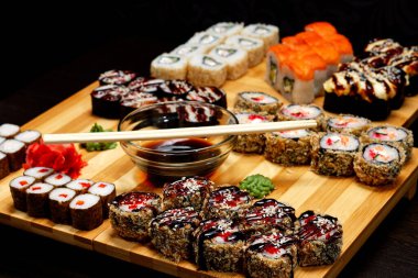 Lezzetli ve lezzetli sıcak ve soğuk suşiler masada. Farklı suşi. Japon mutfağında soslu börek..