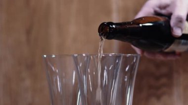 Kahverengi arka planda bir bardak ve bir kupa lezzetli bira standı. Güzel ışığın yaktığı mis kokulu bira iştahı açar..