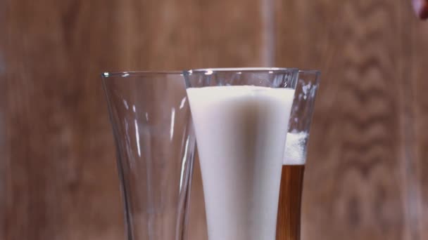 茶色の背景にはグラスとおいしいビールのマグカップが立っています 美しい光に照らされた香り高いビールは食欲を刺激する — ストック動画