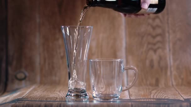 一个杯子和一大杯美味的啤酒倒立在棕色的背景上 芬芳的啤酒被美丽的光线照亮 刺激食欲 — 图库视频影像