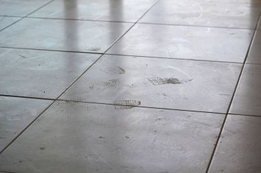 Yerdeki beyaz kutu üzerindeki kirli ayak izleri. Kirli tozlu kat