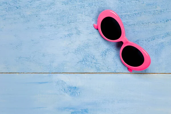 Wesentliche rosa Sonnenbrille Reisegegenstände auf blauem Holz b — Stockfoto