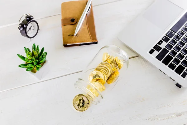 Ahşap masa, beyaz arka plan üzerinde Bitcoin sikke altın sikke izole cryptocurrencies bitcoin yığını üzerinde cam kavanoza Bitcoin sikke altın sikke. Cryptocurrencies en önemli cryptocurrency kavram olarak altın bir bitcoin ile kümesi.