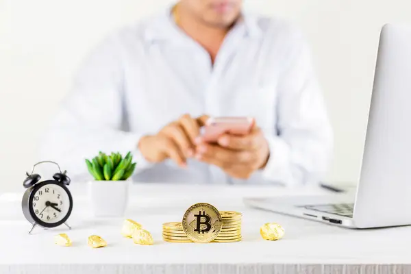 Bitcoin sikke altın sikke Cam Kavanoz ahşap masa üzerinde smartphone için ticari cryptocurrency veya bitcion kullanan adam. Cryptocurrencies en önemli cryptocurrency kavram olarak altın bir bitcoin ile kümesi.