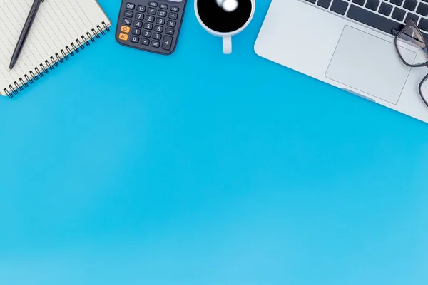 flat lay Office desk table of modern workplace with laptop on blue table, top view laptop background and copy space on black background, blue desk office with laptop, smartphone and other work supplies with mouse.