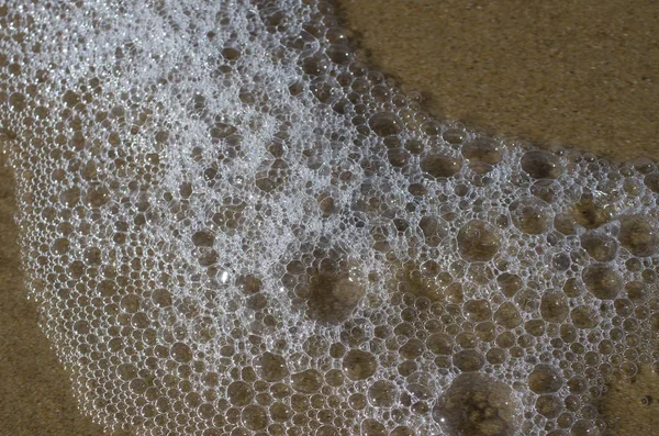 Meereswogen am Sandstrand lizenzfreie Stockbilder
