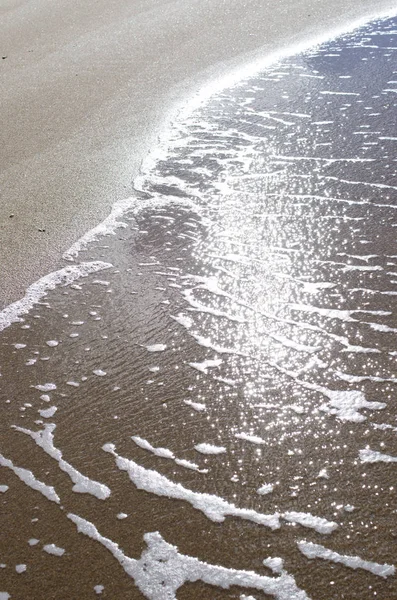 Zachte golf van blauwe oceaan op zandstrand. Achtergrond. — Stockfoto