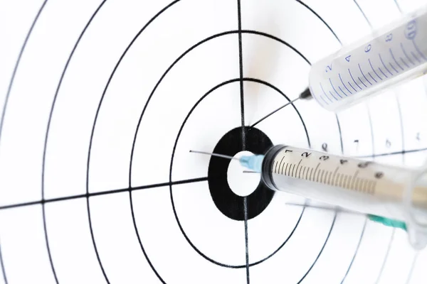 Three medical syringe hit the center of rifle target, humor concept of therapy.