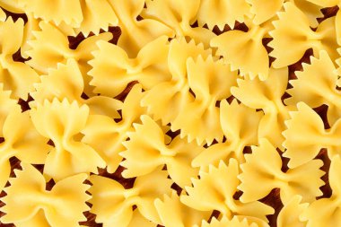 Makarna farfalle, arka planda kahverengi ahşap bir masada geleneksel İtalyan makarnası. Yakın çekim 4