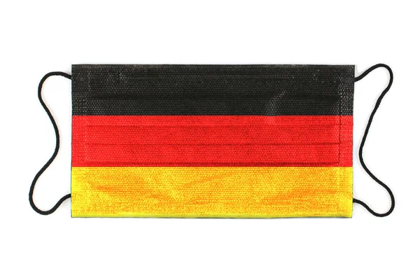 Black medical mask with the image of the German flag. Black medical mask as a symbol of mortal danger Covid-19 in Germany. Close up protective masks textile filter. high resolution isolated on white. — Stock Photo, Image