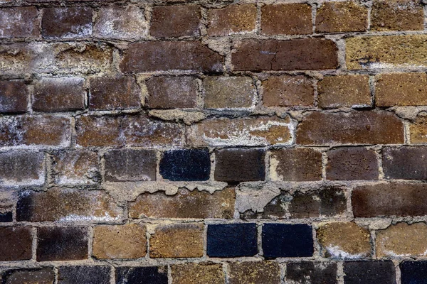 Vecchio edificio con muro di mattoni scuri — Foto Stock