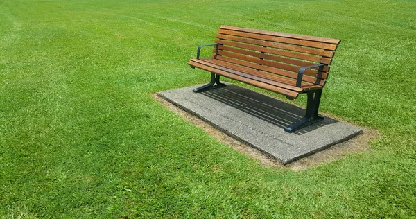 ケアンズの手入れの行き届いた芝生の木製ベンチ — ストック写真