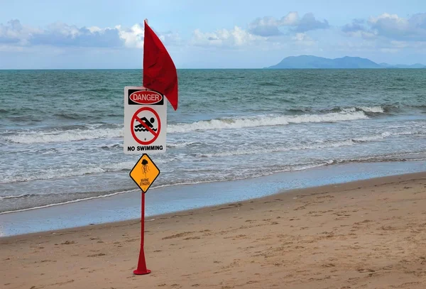 Красный флаг на пляже со знаком "Опасность" — стоковое фото
