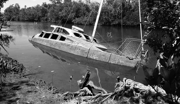 Заброшенный частично затонувший корпус белой моторной яхты — стоковое фото