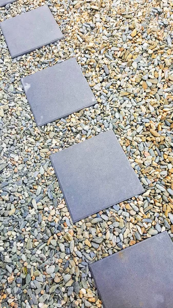 Four pavers surrounded with stones — Stock Photo, Image