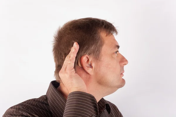 Portrait of a man wearing hearing aid and cupping his hand behin — Stock Photo, Image