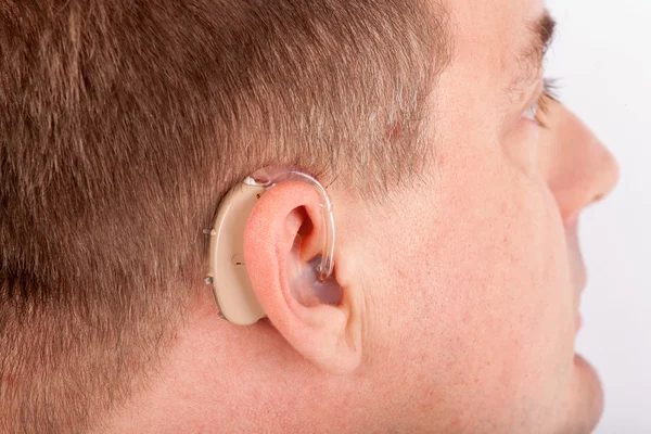 Ear of a man with hearing aid