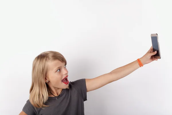 Девушка делает селфи со смартфоном — стоковое фото