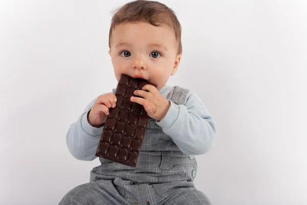 Adorável menino comendo um prato de chocolate . — Fotografia de Stock