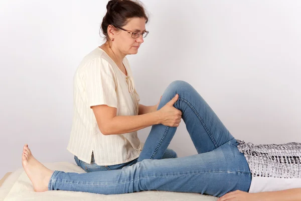Young woman receives bowen therapy for her legs — Stock Photo, Image