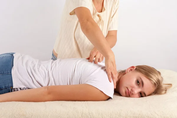 Mujer joven recibe terapia bowen para la espalda y el cuello — Foto de Stock