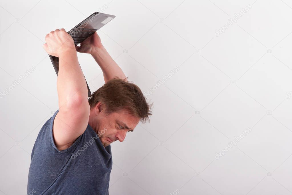 Furioous man smashing his laptop