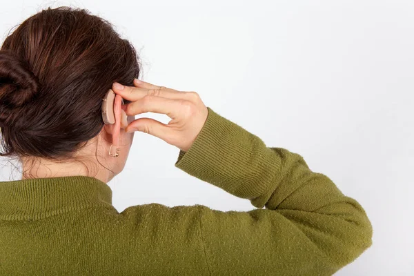 Женщина вставляет свой слуховой аппарат — стоковое фото