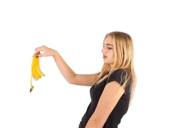 Young woman dropping a banana skin — Stock Photo, Image
