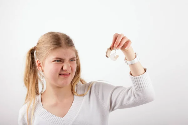 Menina fazendo um grimace com aparelho auditivo — Fotografia de Stock