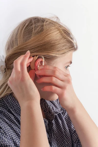 Young woman inserting a hearing aid — Stock Photo, Image