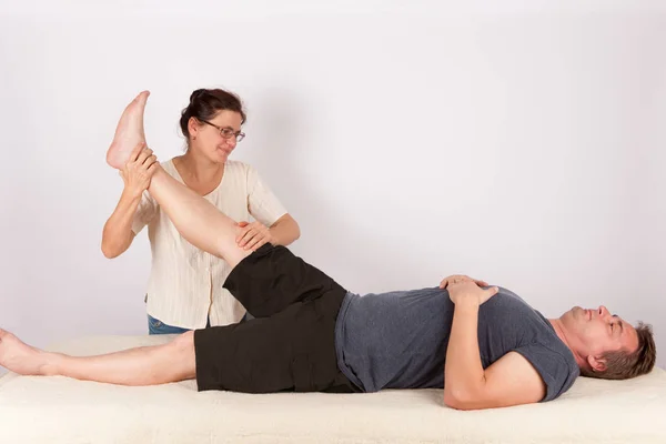 Man krijgt bowen massagebehandeling voor zijn benen. — Stockfoto
