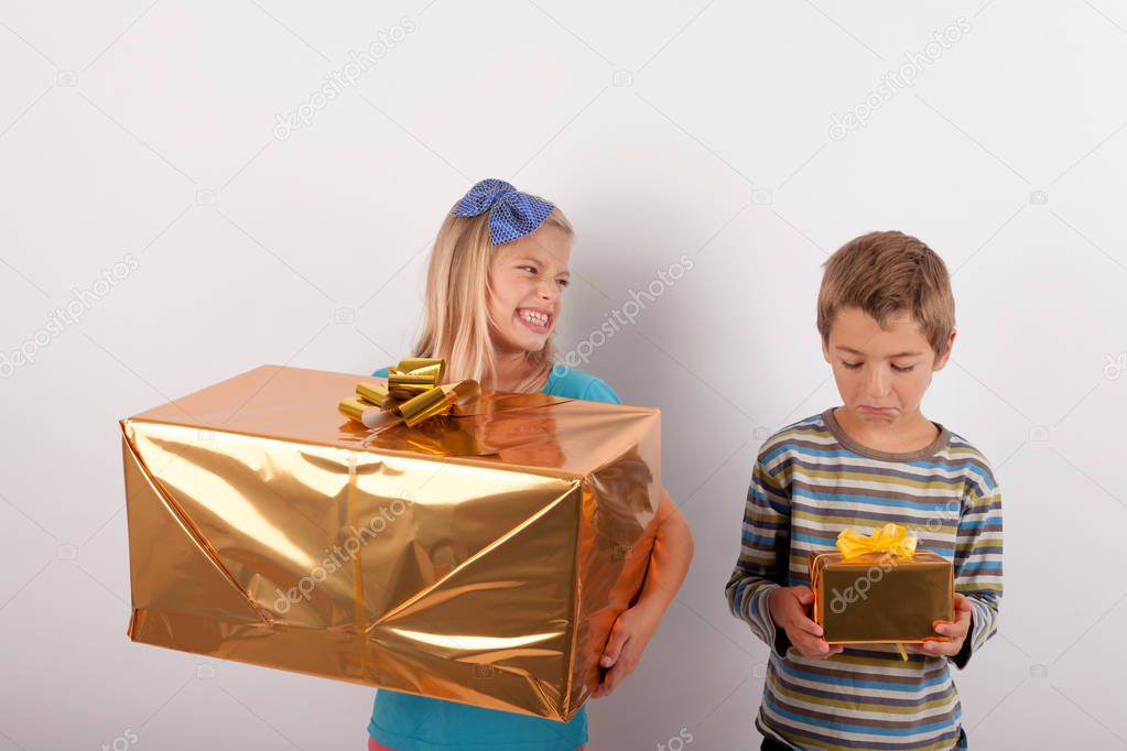 Young girl with big gift box gloating over her brother and his s