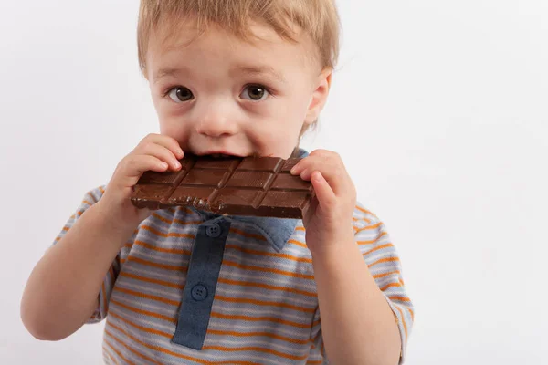 Adorable toddler boy eating a plate of chocolate — Stock Photo, Image